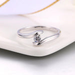 Ring mit gebogener Stange aus Silber und strahlendem Diamanten in der Mitte